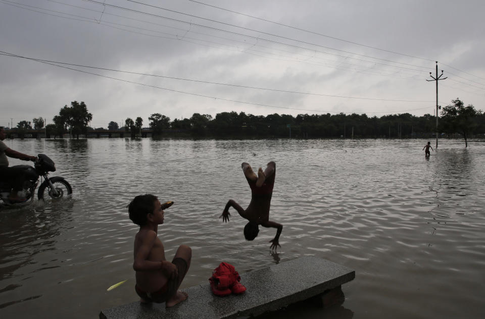 Children play in floodwaters in Prayagraj, in the northern Indian state of Uttar Pradesh, Saturday, Sept. 28, 2019. A heavy spell of retreating monsoon rains has flooded wide areas in northern India, killing dozens of people this week, an official said Saturday. Sandhaya Kureel, a spokeswoman of the Disaster Management and Relief Department, said most of the 59 fatalities were caused by house collapses, lightning and drowning in Uttar Pradesh state. (AP Photo/Rajesh Kumar Singh)