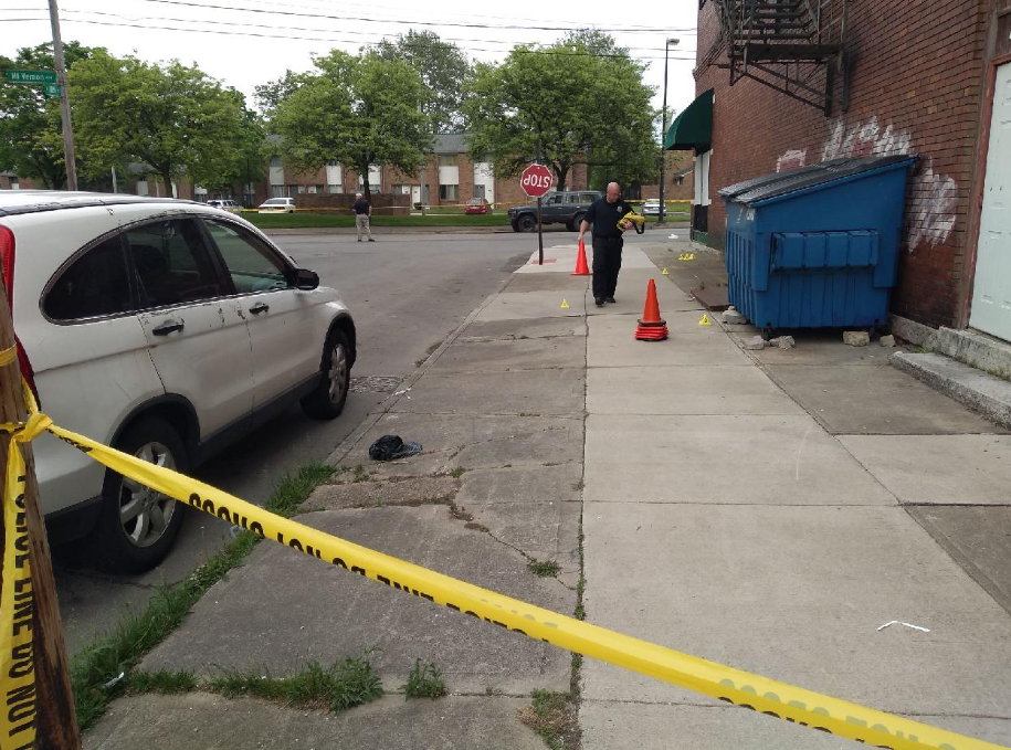 A Columbus police crime scene analyst marks shell casings with small number yellow triangles to replace orange cones at the scene of a fatal shooting Friday afternoon at 18th Street and Mount Vernon Avenue in the city's King-Lincoln Bronzeville neighborhood.