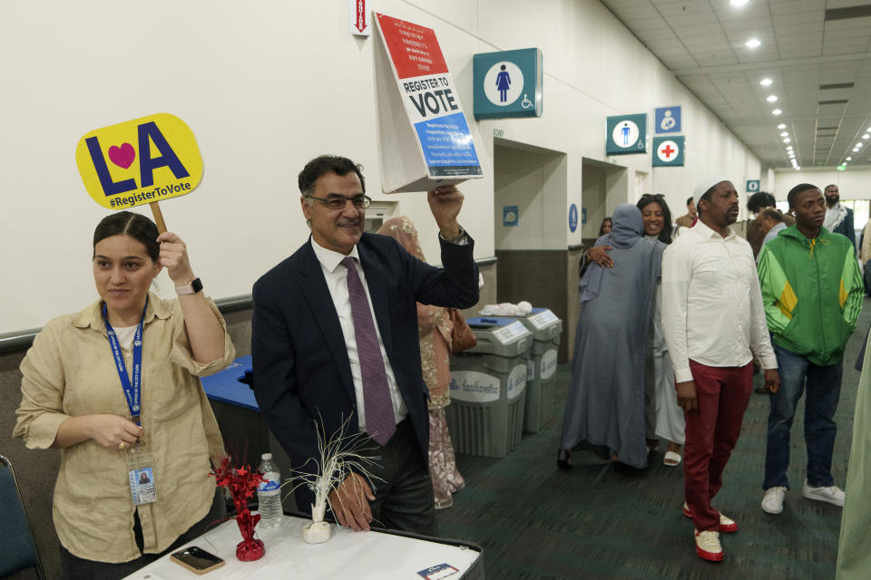 President and co-founder of the Muslim Public Affairs Council, Salam Al-Marayati, second from left, invites American Muslims citizens to register to vote after thousands gathered to mark the end of the holy month of Ramadan in Los Angeles Wednesday, April 10, 2024. As the war in Gaza enters its seventh month, some Muslim and Arab American leaders have grown frustrated with outreach from President Joe Biden's White House. Marayati described the attitude as, “Forget them. They have to learn a lesson. And if they lose, that’s the lesson they should learn.” (AP Photo/Damian Dovarganes)