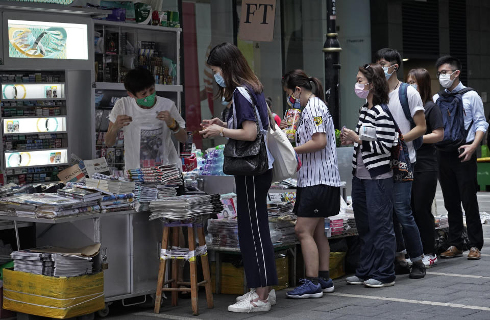 People queue up at a news stand to buy copies of Apple Daily at a downtown street in Hong Kong Tuesday, Aug. 11, 2020, as a show of support, a day after the arrest of its founder Jimmy Lai. Hong Kong authorities arrested media tycoon Jimmy Lai on Monday, broadening their enforcement of a new national security law and stoking fears of a crackdown on the semi-autonomous region's free press.(AP Photo/Vincent Yu)