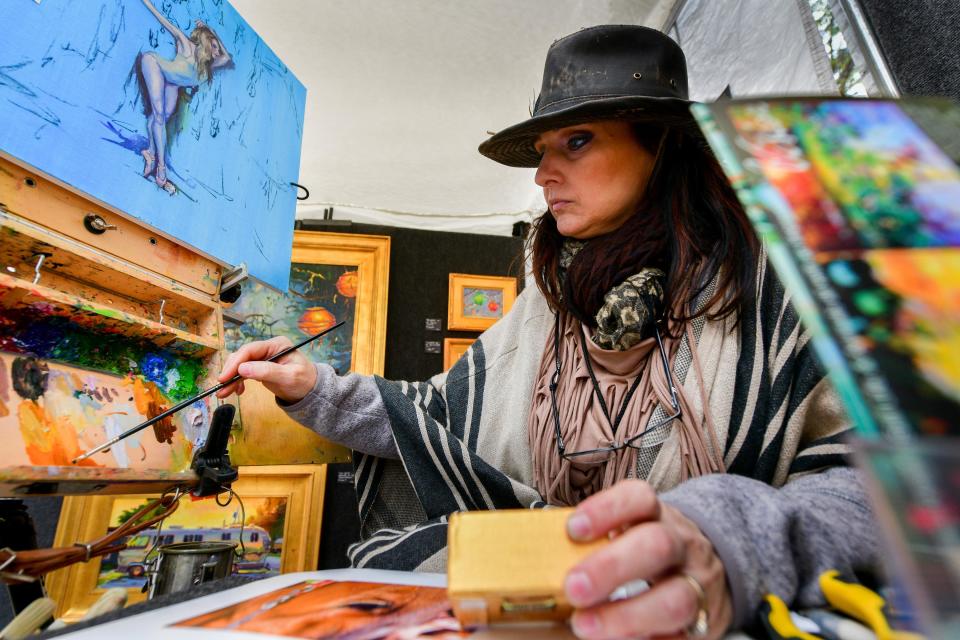 East Peoria artist Tracey Frugoli picks up paint on her brush as she paints a horse eye on a tiny canvas as she shows her art during the Peoria Art Guild Fine Art Fair on the Peoria riverfront in 2018.