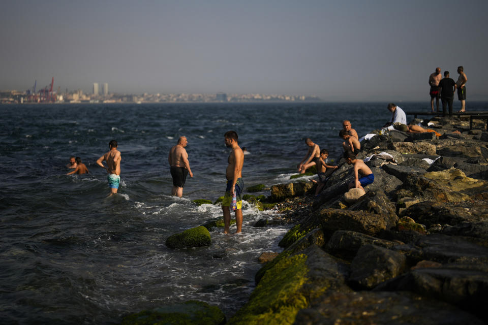 People cool off at the Bosphorus on a hot summer day in Istanbul, Turkey, Thursday, July 13, 2023. (AP Photo/Francisco Seco)