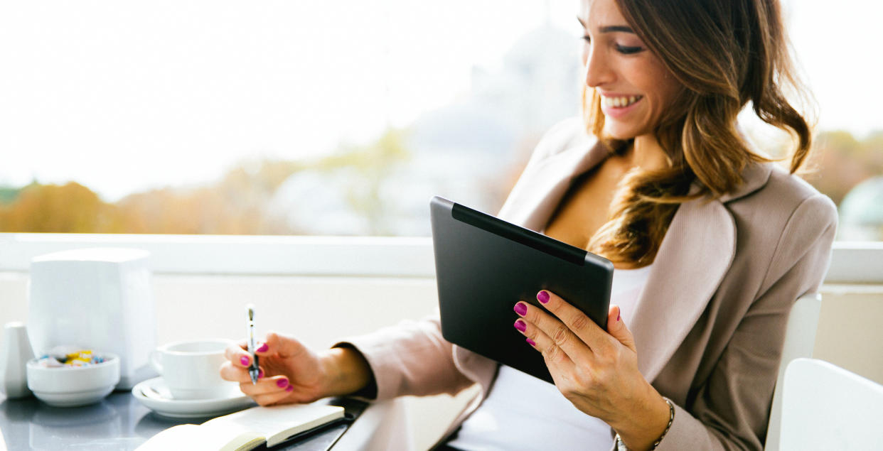 woman on tablet taking notes