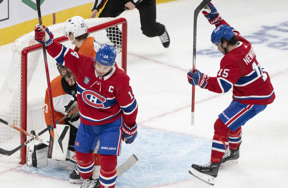 Montreal Canadiens' Nick Suzuki (14) and Alex Newhook (15) celebrate a goal against Philadelphia Flyers goaltender Samuel Ersson (33) during the first period of an NHL hockey game Thursday, March 28, 2024, in Montreal. (Christinne Muschi/The Canadian Press via AP)