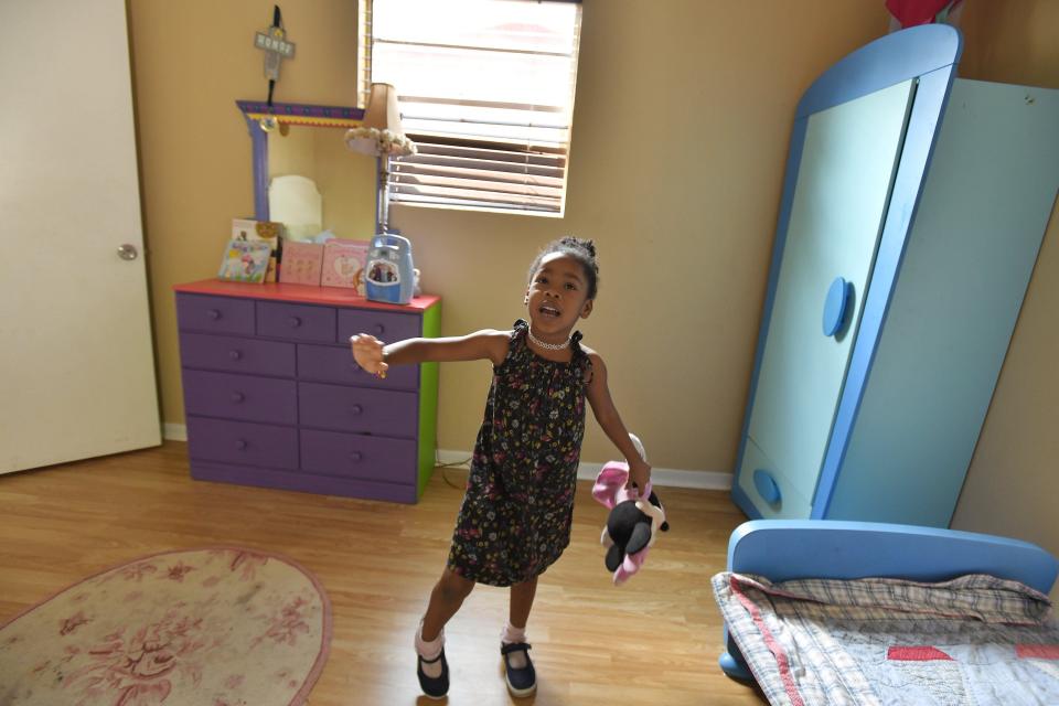 Kamari Phillips, 5, plays in the bedroom she shares with her older brother in her family's rental home in Jacksonville. They were homeless for three months last year.