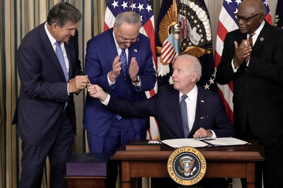 President Joe Biden gives Sen. Joe Manchin, D-W.Va., the pen he used to sign the Inflation Reduction Act.