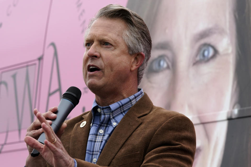 U.S. Rep. Roger Marshall, R-Kan., talks to the crowd in front of photo of Supreme Court nominee Amy Coney Barrett while attending a Concerned Women for America event outside a gun store in Kansas City, Kan. Wednesday, Oct. 21, 2020. Marshall is facing stiff competition from state Sen. Barbara Bollier in the race to fill an open Senate seat in Kansas. (AP Photo/Charlie Riedel)