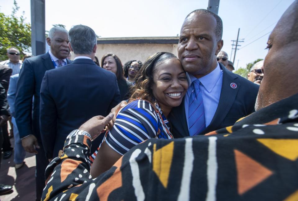 Lora Dene King, left, hugs John Hope Bryant