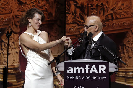 72nd Cannes Film Festival - The amfAR's Cinema Against AIDS 2019 event - Antibes, France, May 23, 2019. Milla Jovovich and William H. Roedy, Chairman of amfAR, during the auction. REUTERS/Eric Gaillard