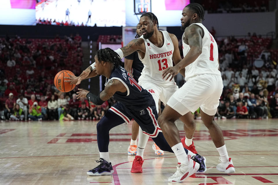Jackson State guard Chase Adams (10) fights out of a double team by Houston forward J'Wan Roberts (13) and guard Jamal Shead (1) during the first half of an NCAA college basketball game, Saturday, Dec. 9, 2023, in Houston. (AP Photo/Kevin M. Cox)