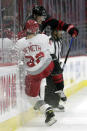 Detroit Red Wings' Patrik Nemeth (22) is checked by Carolina Hurricanes' Jesper Fast (71) during the second period of an NHL hockey game in Raleigh, N.C., Thursday, March 4, 2021. (AP Photo/Chris Seward)