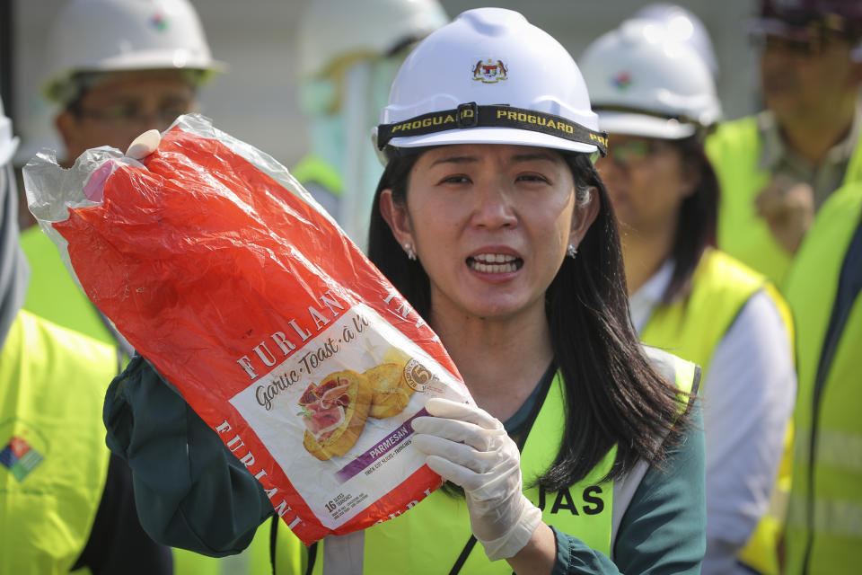 Malaysia's Minister of Energy, Science, Technology, Environment and Climate Change Yeo Bee Yin shows a sample of plastic waste shipment in Port Klang, Malaysia, Tuesday, May 28, 2019. Malaysia says it will send back some 3,000 metric tonnes (330 tons) of non-recyclable plastic waste to countries including the U.S., U.K., Canada and Australia in a move to avoid becoming a dumping ground for rich nations. (AP Photo/Vincent Thian)
