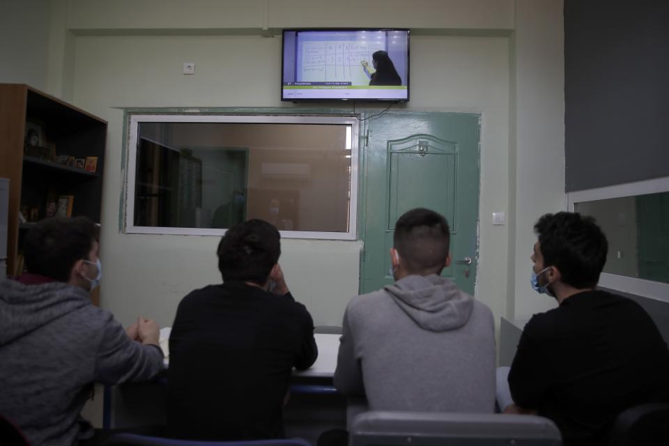 Inmates watch mathematics on "Prospathodas TV," or "Trying TV," the channel of Avlona's prison school, north of Athens, Wednesday, Feb. 10, 2021. With Greece's schools shut due to the pandemic, all lessons have gone online. But the online world isn't within reach of everyone _ and particularly not within reach of the students of Avlona Special Youth Detention Center, where internet devices are banned by law from the cells. (AP Photo/Thanassis Stavrakis)