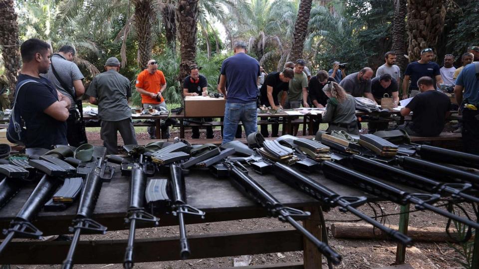 PHOTO: Israelis arrive at a weapons distribution point for people allowed to carry arms, at the Ayyelet HaShahar Kibbutz, in northern Israel, near the Lebanese border on October 12, 2023. (Jalaa Marey/AFP via Getty Images)