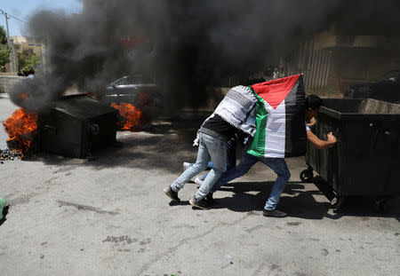 Palestinian protesters push a garbage container during clashes with Israeli troops following a protest in solidarity with Palestinian prisoners held by Israel, in the West Bank town of Bethlehem April 17, 2017. REUTERS/Ammar Awad