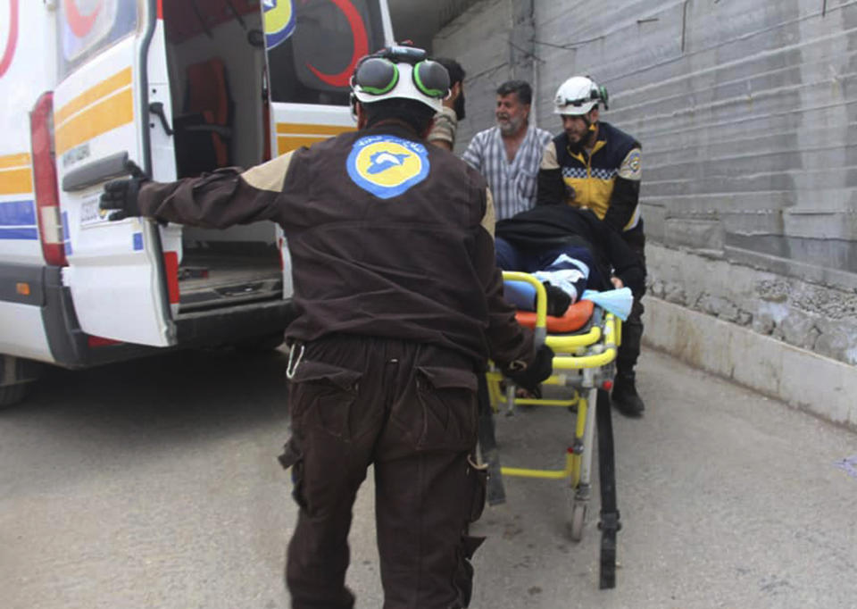 This photo provided by the Syrian Civil Defense White Helmets, which has been authenticated based on its contents and other AP reporting, shows a civil defense worker carry an injured man after shelling hit a street in the town of Ehssem, southern Idlib, Syria, Friday, May 3, 2019. Syrian state media and activists are reporting a wave of government and Russian airstrikes, including indiscriminate barrel bombs, on the rebel-held enclave in northwestern Syria where a seven-month truce is teetering under a violent escalation. (Syrian Civil Defense White Helmets via AP)