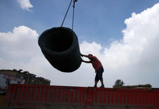 This photo, taken on August 6, shows a worker unloading steel bars at a factory in Huaibei, east China's Anhui province. Foreign direct investment in China fell 8.7 percent in July, the government said on Thursday, as the economy continues to feel the pinch of slowing global growth and the European debt crisis