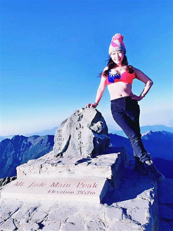 彰化縣議員劉惠娟在零下五度登上玉山主峰，換上國旗內衣與石碑合影。（取自臉書）
