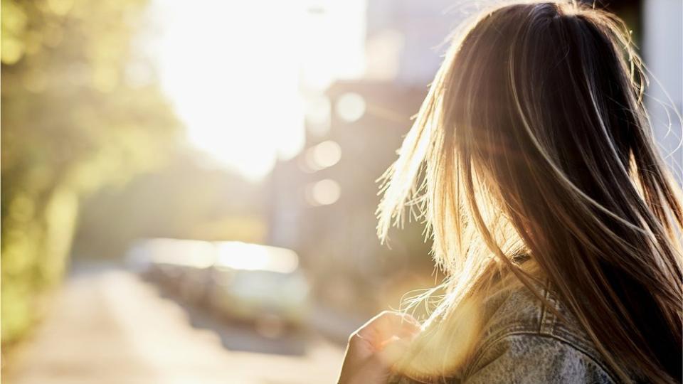 Mujer caminando bajo el sol