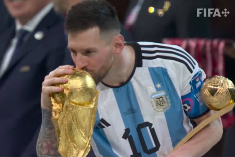 Lionel Messi, con el Balón de Oro de Qatar 2022, besa la Copa del Mundo