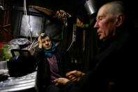 Tamara and Yuri Baikov, both 69, listen to the radio inside their hut situated in a forest near the village of Yukhovichi, Belarus, February 7, 2018. REUTERS/Vasily Fedosenko