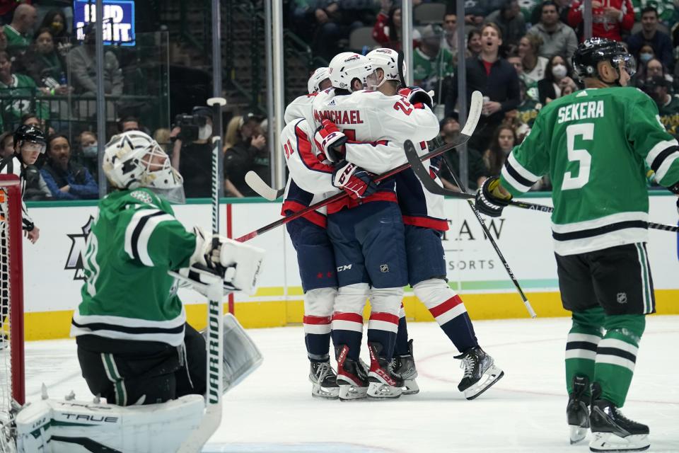 Dallas Stars goaltender Braden Holtby left, and Andrej Sekera (5) stand nearby as Washington Capitals center Connor McMichael, center rear, celebrates with Joe Snively, center left, and Lars Eller, center right, after McMichael scored in the second period of an NHL hockey game in Dallas, Friday, Jan. 28, 2022. (AP Photo/Tony Gutierrez)