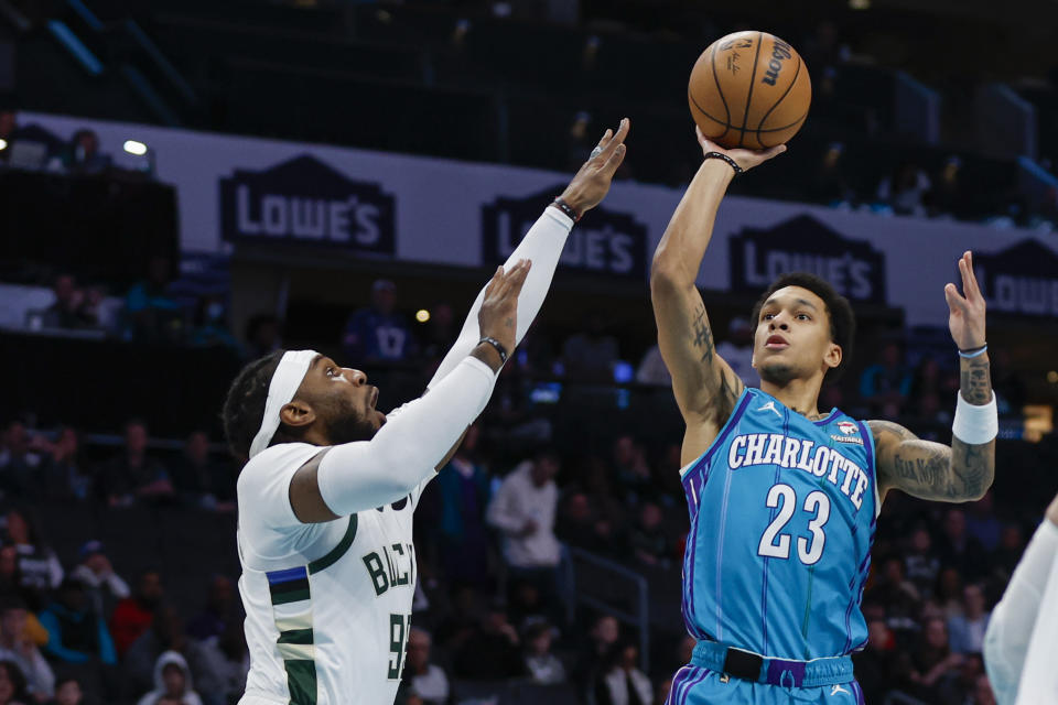 Charlotte Hornets guard Tre Mann (23) looks to shoot over Milwaukee Bucks forward Jae Crowder, left, during the first half of an NBA basketball game in Charlotte, N.C., Thursday, Feb. 29, 2024. (AP Photo/Nell Redmond)