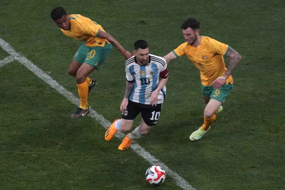Argentina's Lionel Messi gets the ball past Australia's players during a friendly soccer match held at the Worker's Stadium in Beijing, Thursday, June 15, 2023. (AP Photo/Ng Han Guan)