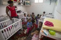 A woman takes care of children from families of illegal African immigrants at a so-called day-care centre in southern Tel Aviv, on May 28, 2015