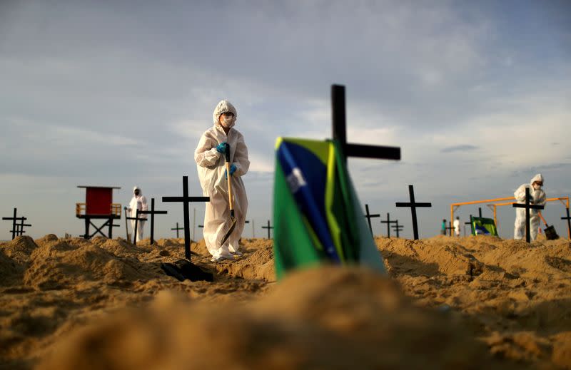 Activists of the NGO Rio de Paz in protective gear dig graves on Copacabana beach to symbolise the dead from the coronavirus disease (COVID-19), during a demonstration in Rio de Janeiro