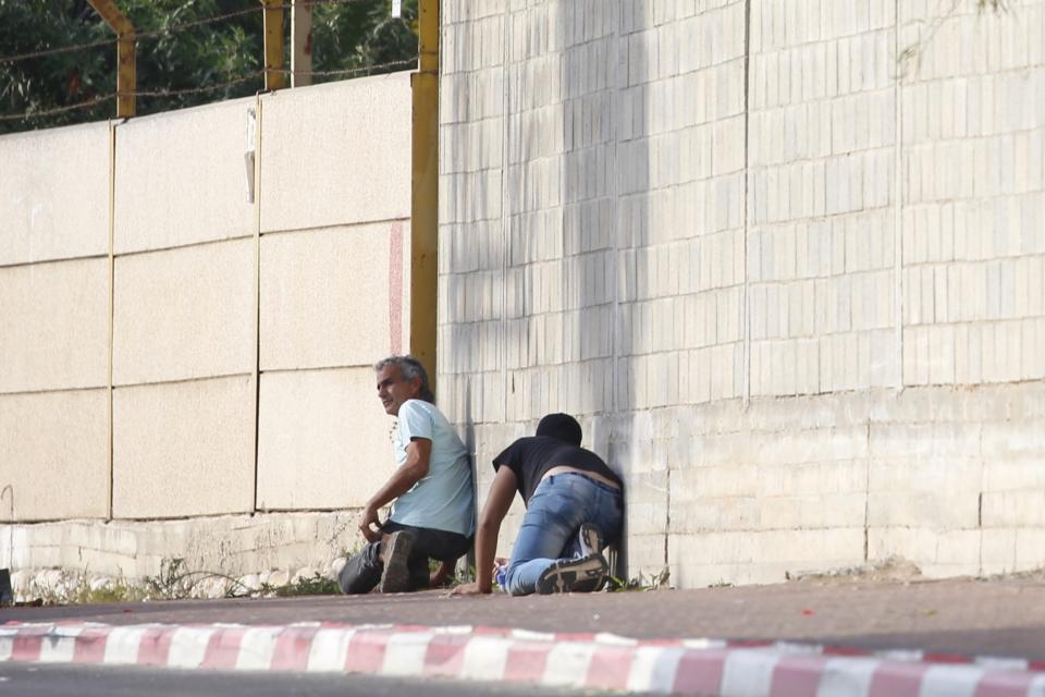 People take cover during an air-raid warning siren in Sderot, southern Israel, Wednesday, Nov. 13, 2019. (AP Photo/Ariel Schalit)