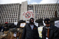 Masked pro-Russia protesters stand guard at a barricade outside a regional government building in Donetsk, in eastern Ukraine April 15, 2014. The sign reads, "No to fascism." REUTERS/Marko Djurica