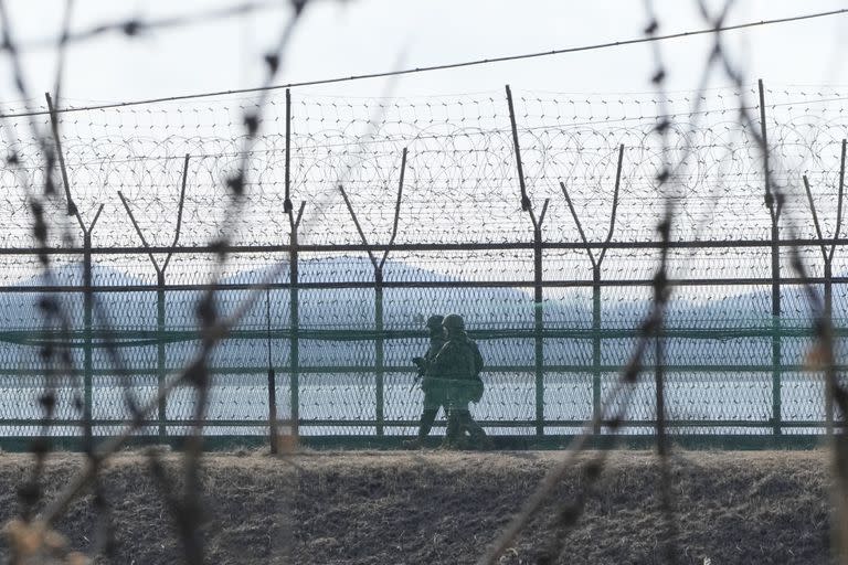 Soldados del ejército surcoreano patrullan junto a la cerca de alambre de espino en Paju, Corea del Sur, cerca de la frontera con Corea del Norte, el jueves 16 de febrero de 2023. (AP Foto/Ahn Young-joon)