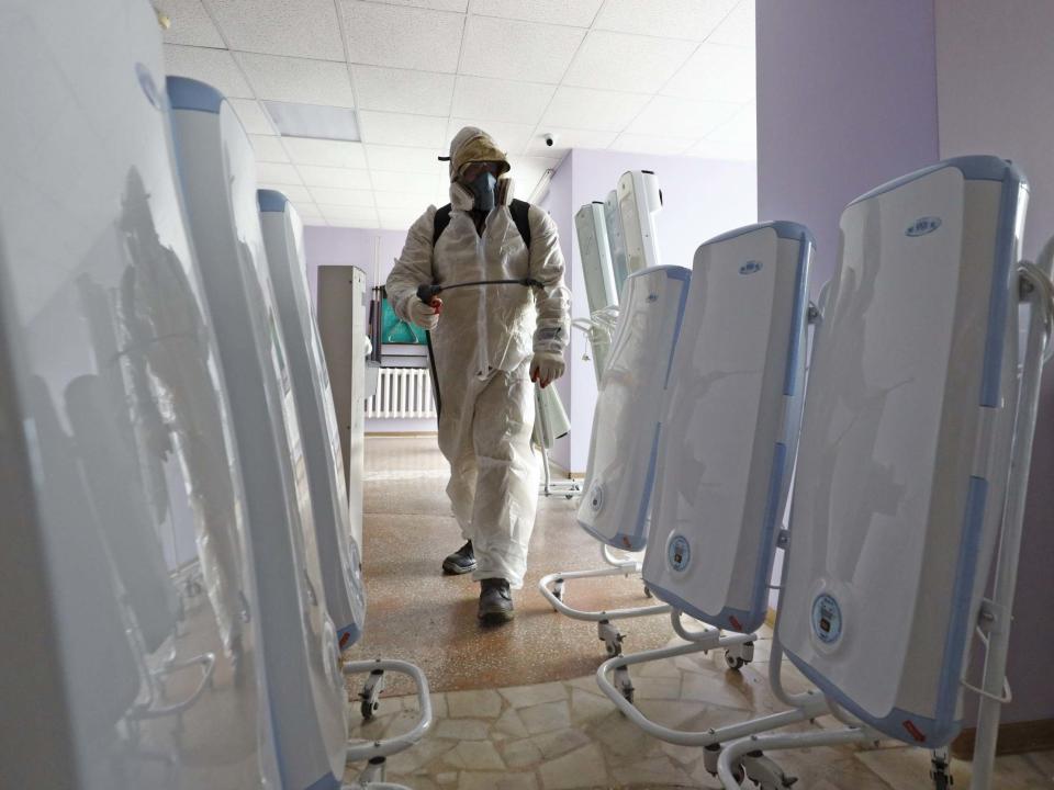 A worker in a chemical suit sprays disinfectant in a quarantine facility at the Gradostroitel health resort near the city of Tyumen after a 14-day quarantine for Russian nationals who were evacuated from Wuhan: Maxim Slutsky/TASS