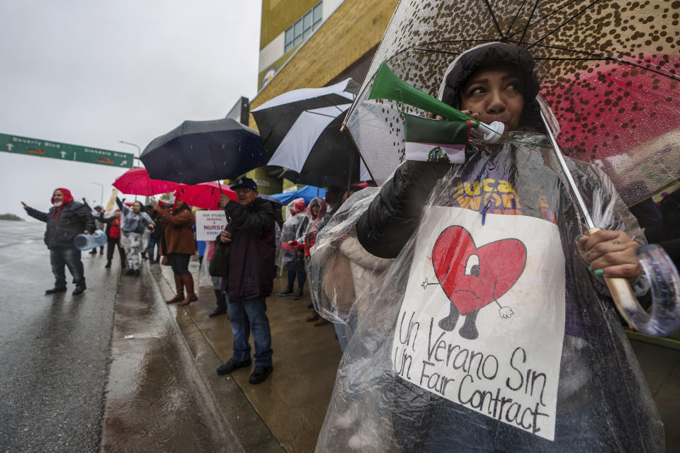 Los Angeles Unified School District, LAUSD teachers and Service Employees International Union 99 (SEIU) members strike under heavy rain asking for a fair contract outside the Edward R. Roybal Learning Center in Los Angeles Tuesday, March 21, 2023. Tens of thousands of workers in the LAUSD are walking off the job over stalled contract talks. (AP Photo/Damian Dovarganes)