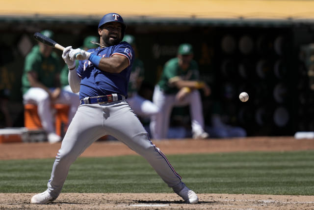 Texas Rangers' Ezequiel Duran, right, dives back to first base