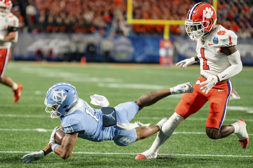 North Carolina wide receiver Josh Downs (11) makes a catch while covered by Clemson safety Andrew Mukuba (1) in the first half during the Atlantic Coast Conference championship NCAA college football game on Saturday, Dec. 3, 2022, in Charlotte, N.C. (AP Photo/Jacob Kupferman)