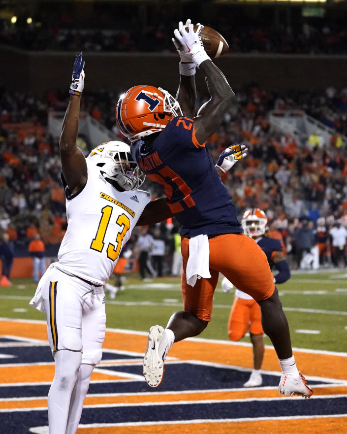 Illinois defensive back Jartavius Martin (21) intercepts a pass intended for Chattanooga wide receiver Tyron Arnett in the end zone during the first half of an NCAA college football game Thursday, Sept. 22, 2022, in Champaign, Ill. (AP Photo/Charles Rex Arbogast)