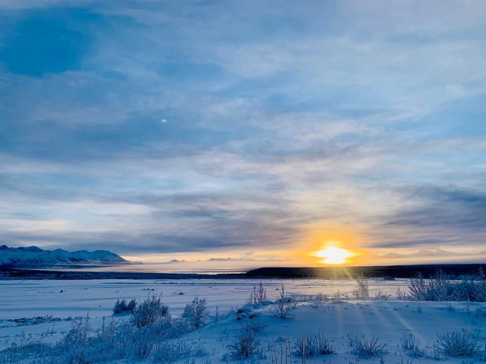 Snow covered prairie with sun setting