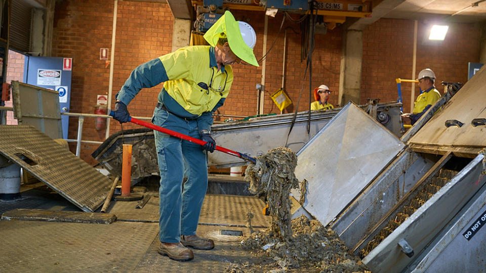 A Urban Utilities staff member pulls apart a blockage at the Queensland facility.