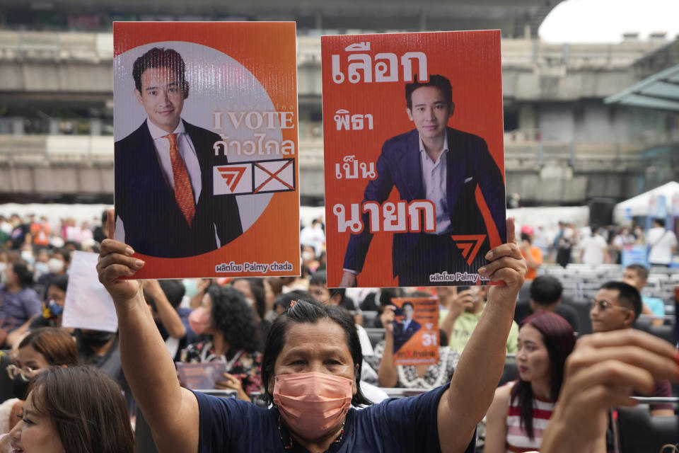 A supporter of Move Forward Party holds posters which reads " I vote Move Forward Vote Pita to be next Prime Minister" during a general election in Bangkok, Thailand, May 11, 2023. Voters disaffected by nine years of plodding rule by a coup-making army general are expected to deliver a strong mandate for change in Thailand's general election Sunday, May 14, 2023. (AP Photo/Sakchai Lalit)