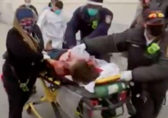 A woman is wheeled away from the US Capitol on a stretcher after she was shot. 