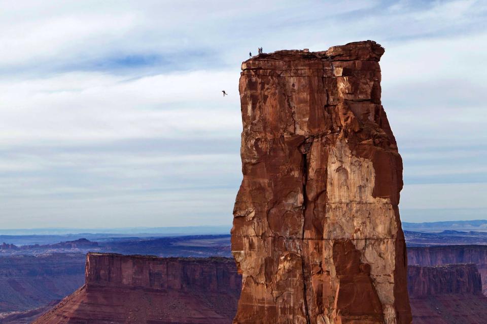 Thrill seeker Michael Tomchek plunges 400ft from the top of a cliff. He will pull his parachute with only seconds to spare before he hits the ground (CATERS)