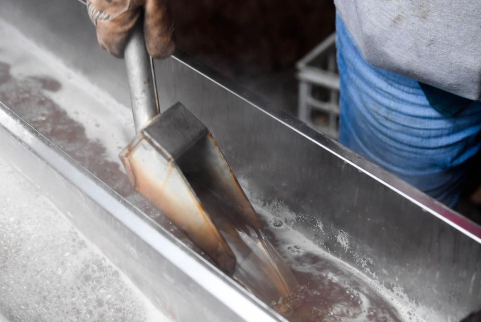 Volunteer LeeAnne Bruner us a scoop to stir maple syrup she is cooking, as maple syrup production is under way at the Wesselman Woods Nature Preserve for the park’s Annual Sugarbush Festival, Tuesday, February 5, 2019.