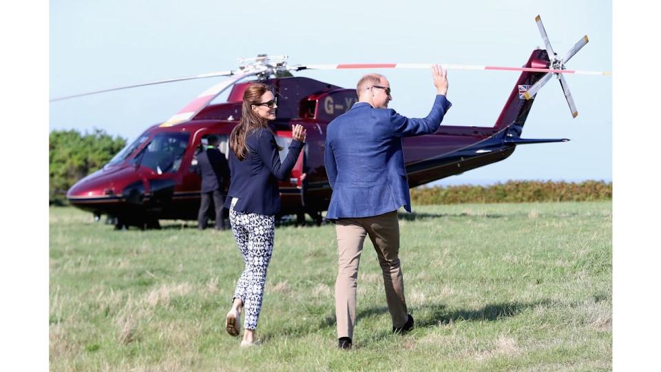 Prince William and Princess Kate wave as they head back to the Royal helicopter after visiting the Island of St Martin's in the Scilly Isles on September 2, 2016