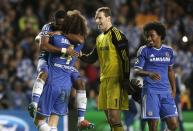 Chelsea's Samuel Eto'o, left goes to hug teammate David Lui, watched by goalkeeper Petr Cech and C Willian after Chelsea defeated Paris Saint-Germain in the Champions League quarterfinal second leg soccer match between Chelsea and Paris Saint Germain at Stamford Bridge stadium in London, Tuesday, April 8, 2014. Chelsea advance to the semifinals. (AP Photo/Matt Dunham).