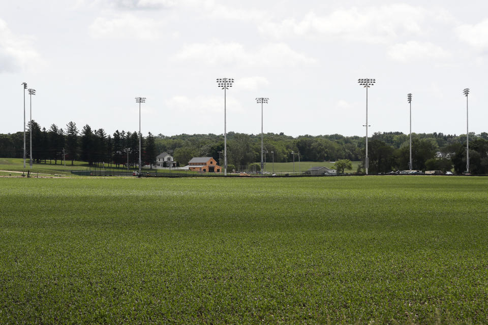 Light stands from a baseball field being built near the Field of Dreams movie site, rear, are seen, Friday, June 5, 2020, in Dyersville, Iowa. Major League Baseball is building the field a few hundred yards down a corn-lined path from the famous movie site in eastern Iowa but unlike the original, it's unclear whether teams will show up for a game this time as the league and its players struggle to agree on plans for a coronavirus-shortened season. (AP Photo/Charlie Neibergall)