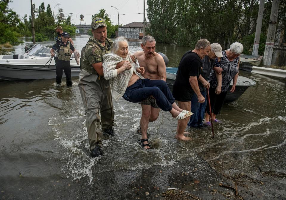 Rescuers evacuate local residents from a flooded area after the Nova Kakhovka dam breached, amid Russia's attack on Ukraine, in Kherson, Ukraine June 7, 2023.