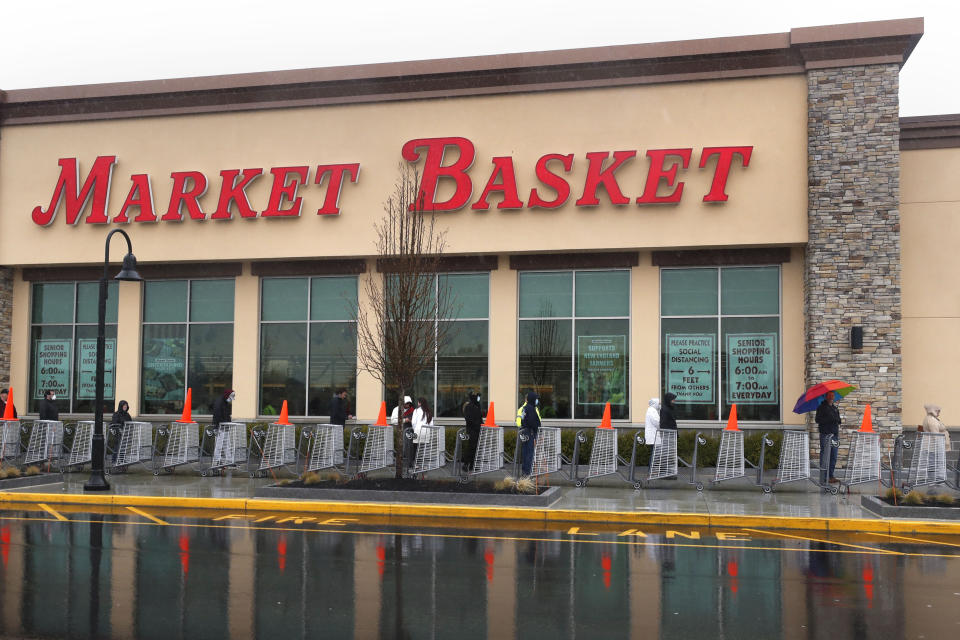Shoppers wait in line as customer capacity is limited due to the virus outbreak at the Market Basket store in Salem, N.H., Friday, April 3, 2020. (AP Photo/Charles Krupa)