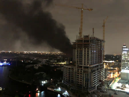 Smoke rises after a fire broke out at an electrical substation (obscured by building) in Fort Lauderdale, Florida, U.S., March 26, 2019 in this photo taken from social media. GEORGE C PALAIDIS via REUTERS